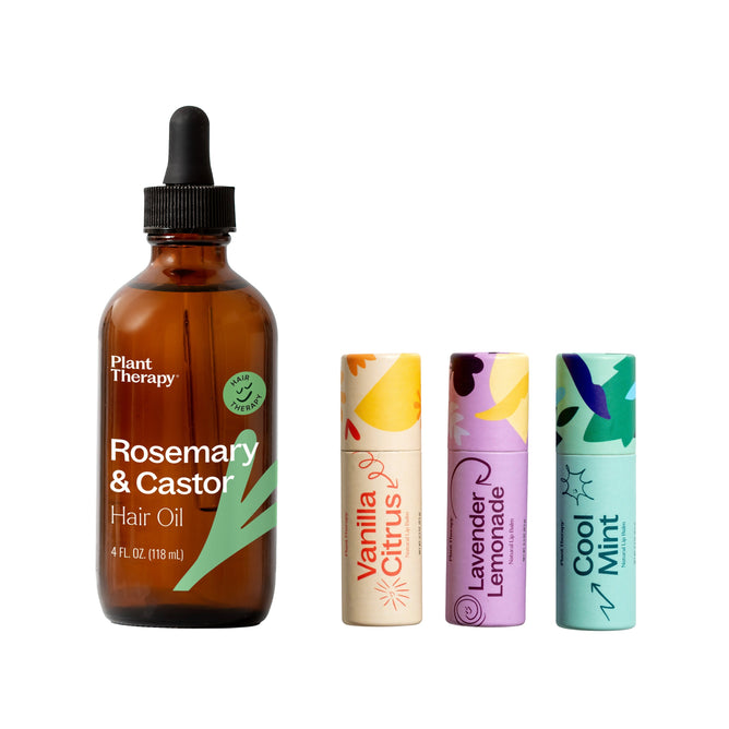 A brown Plant Therapy Rosemary & Castor Hair Oil bottle stands next to three colorful lip balms—Vanilla Citrus, Lavender Lemonade, and Cool Mint—on a white background. The set includes a free gift.