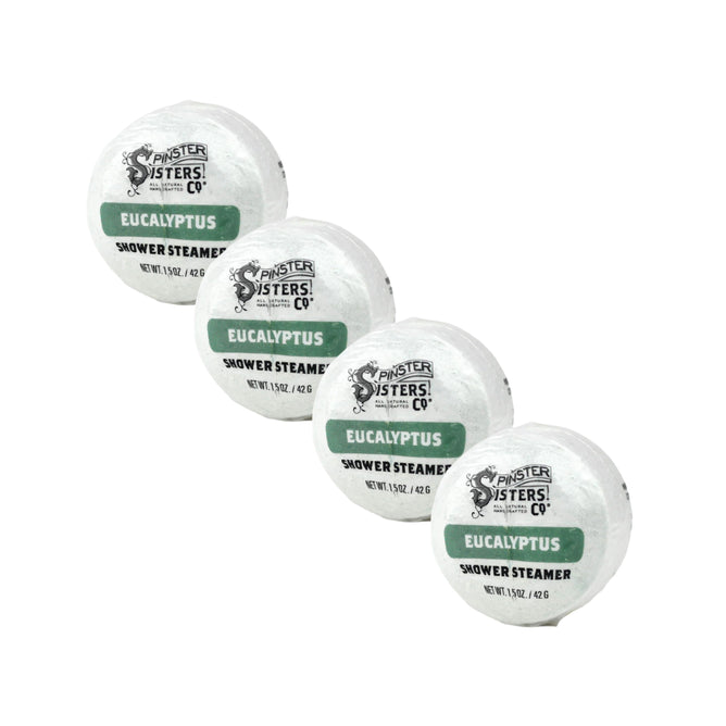 Four round Spinster Sisters Co. Eucalyptus Shower Steamers from the Eucalyptus Shower Steamers Set, each in white packaging with green labels, are arranged diagonally on a white background.