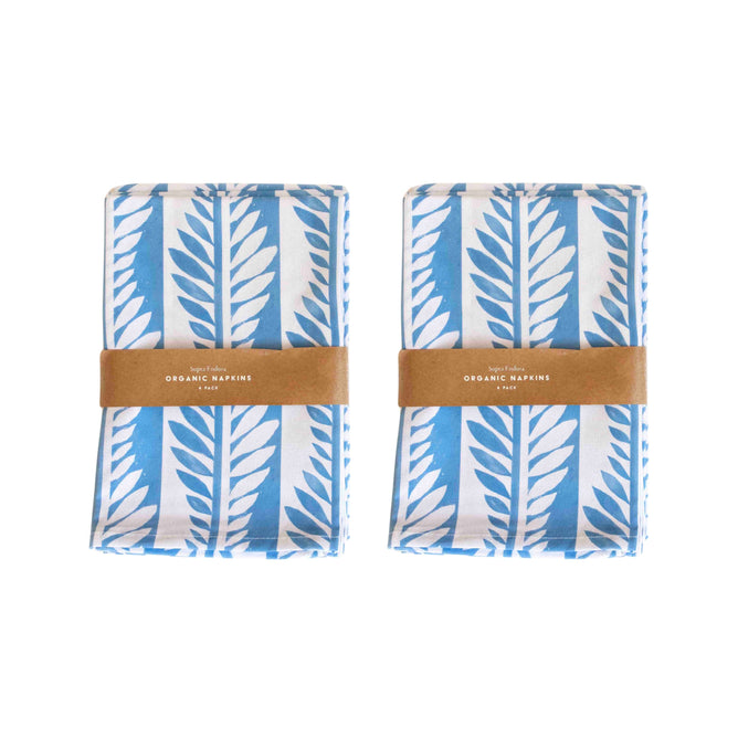 Two sets of Supra Enduras Organic Cotton Napkins, free gift included, feature a blue and white leaf pattern like delicate blue vines. Wrapped in brown paper bands labeled Organic Napkins, they make a perfect hostess gift.