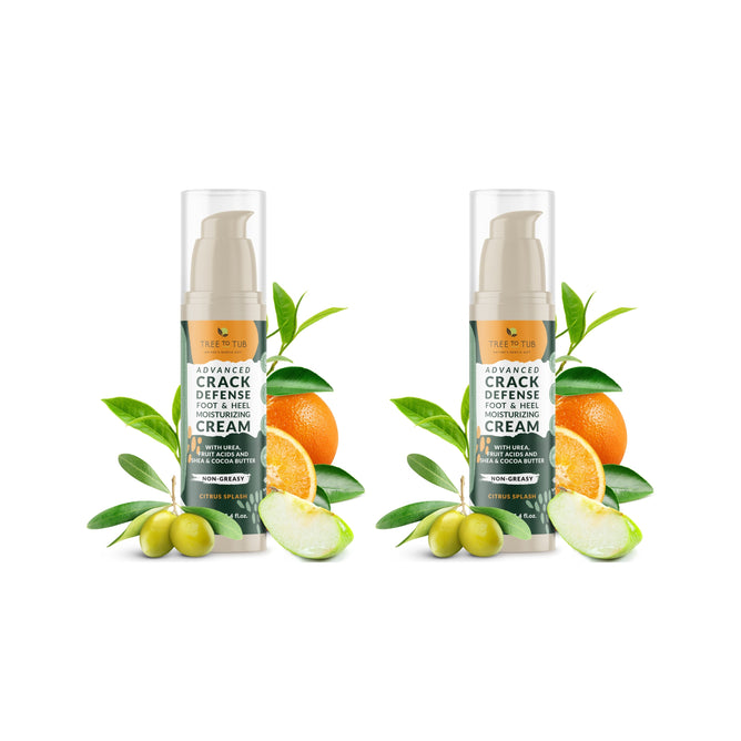 Two bottles of Tree To Tubs Advanced Crack Defense Deep Moisturizing Heel & Foot Cream + free gift are shown amid fresh oranges, limes, and olives on a white background. This cream is your solution for dry, cracked heels.