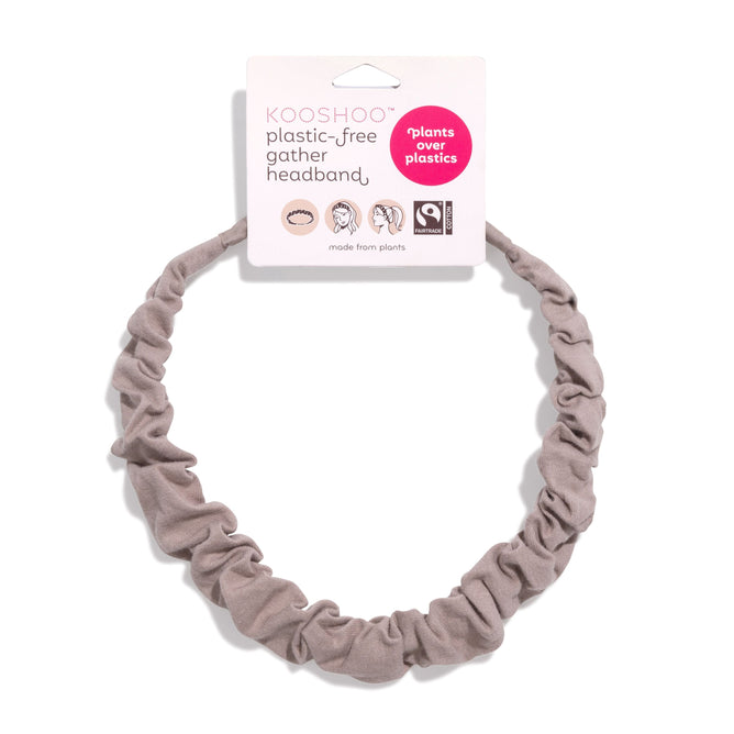 The KOOSHOO Gather Headband, a light brown, Fairtrade-certified organic cotton accessory with plants over plastics and KOOSHOO plastic-free gather headband tags, is shown on a white background.