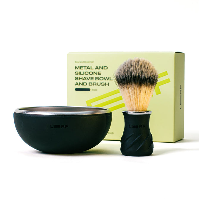 A Leaf Shave Bowl & Brush Set with light bristles is displayed before a yellow box, offering a creamy lather for every shave.