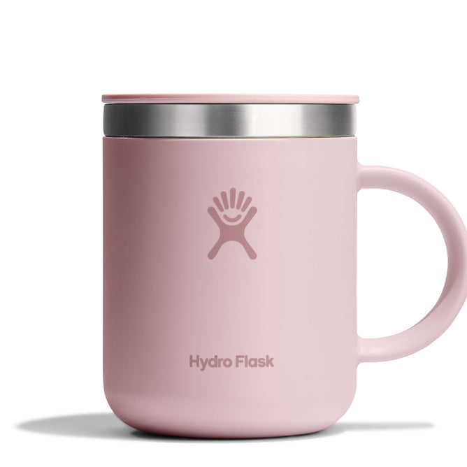 The Hydro Flask Stainless Steel Mug, 12 oz in light pink, features a handle and splash-resistant lid with a stainless steel rim. The prominent Hydro Flask logo on the insulated mugs side ensures style and functionality.
