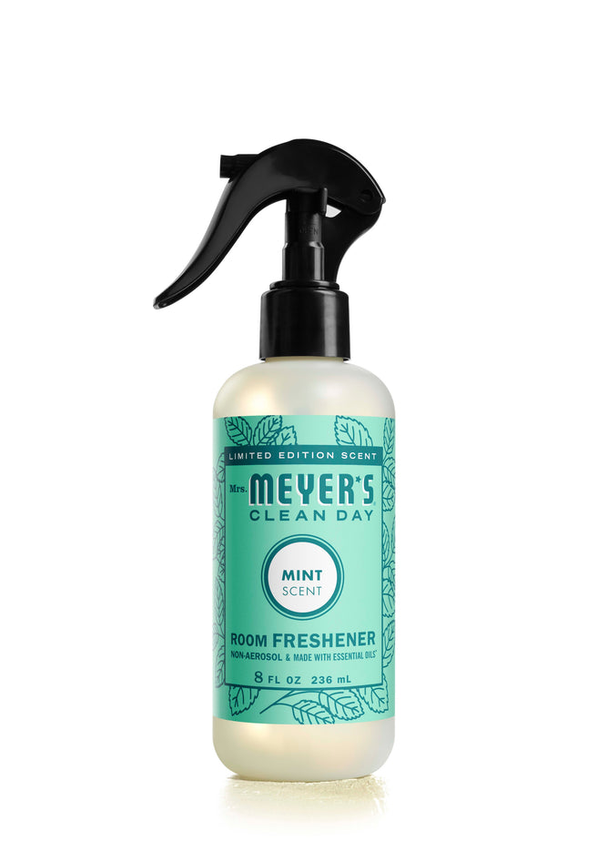 The 8 fl oz Mrs. Meyers Room Freshener in mint scent, with essential oils, instantly enhances any space. Its label features leaf designs stating Limited Edition Scent, and the bottle includes a spray nozzle for easy use.