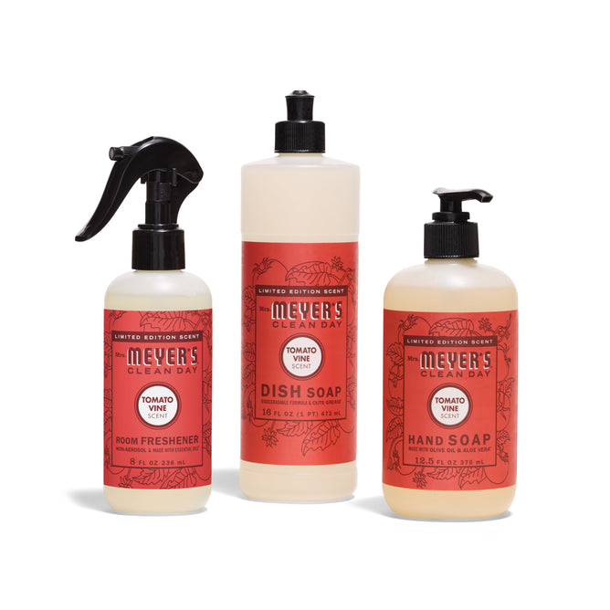 Three bottles of Mrs. Meyer’s Scents & Sun Essentials - Tomato Vine are shown: Room Refresher spray, Dish Soap with a pump, and Hand Soap with a pump, each with red labels on white bottles.