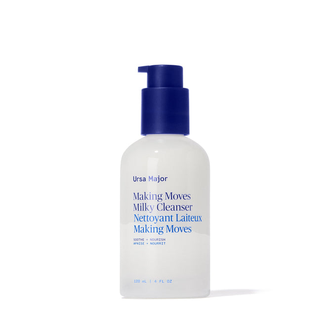 A white bottle of Ursa Major’s Making Moves Milky Cleanser with a blue pump and blue label text stands upright on a white background; this enzyme-powered facial milk gently exfoliates and hydrates.