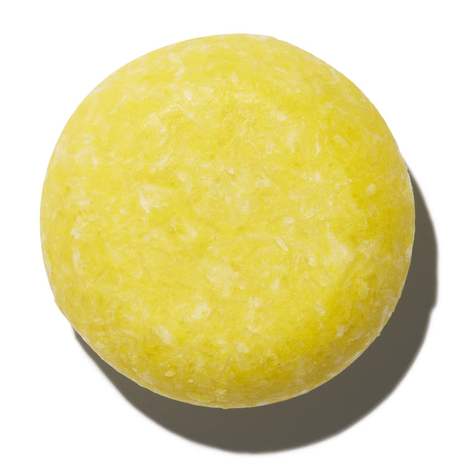 The NOT!CE Hair Co Sorrento Shampoo Bar is round and bright yellow with a lightly textured surface, shown on a plain white background—an ideal plastic-free choice for hair care.