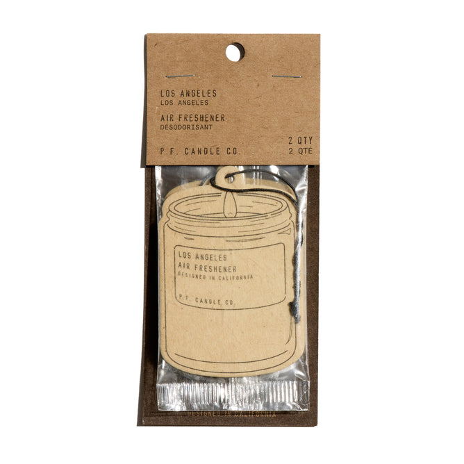 The P.F. Candle Co. Car Freshener, shaped like a candle jar with a brown label and packaged in clear plastic with a kraft paper header, is perfect for instantly refreshing any space.