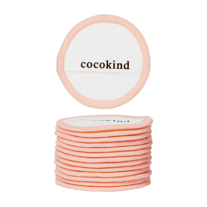 A stack of Cocokind Reusable Cotton Pads with light pink edges; the top pad, shown separately above, features cocokind printed in black on a white background.