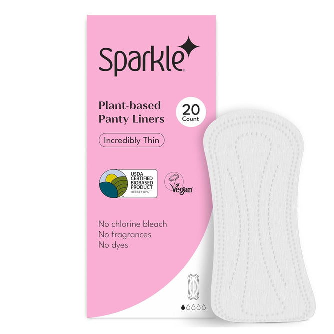 A box of Sparkle Panty Liners with a white liner beside it. The pink and white packaging features “Incredibly Thin,” “20 Count,” and notes no chlorine bleach, fragrances, or dyes, along with certification logos.
