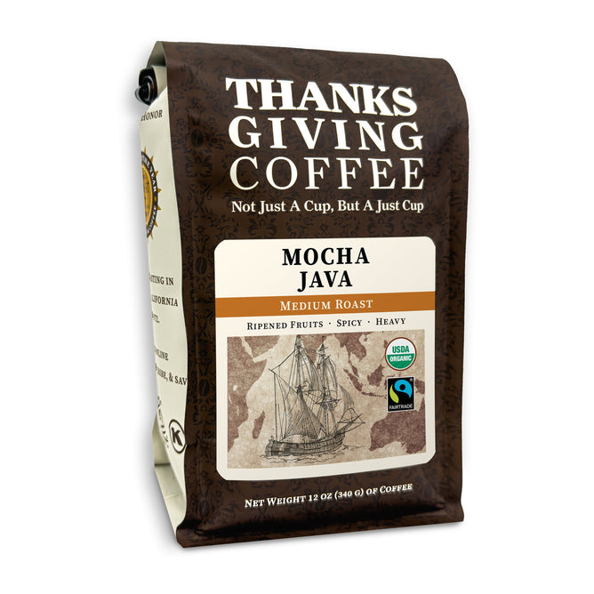 A brown package of Thanksgiving Coffees Organic Mocha Java features a vintage ship illustration, USDA Organic and Fair Trade labels, with notes of ripe fruits and spice. It weighs 12 oz (340 g).