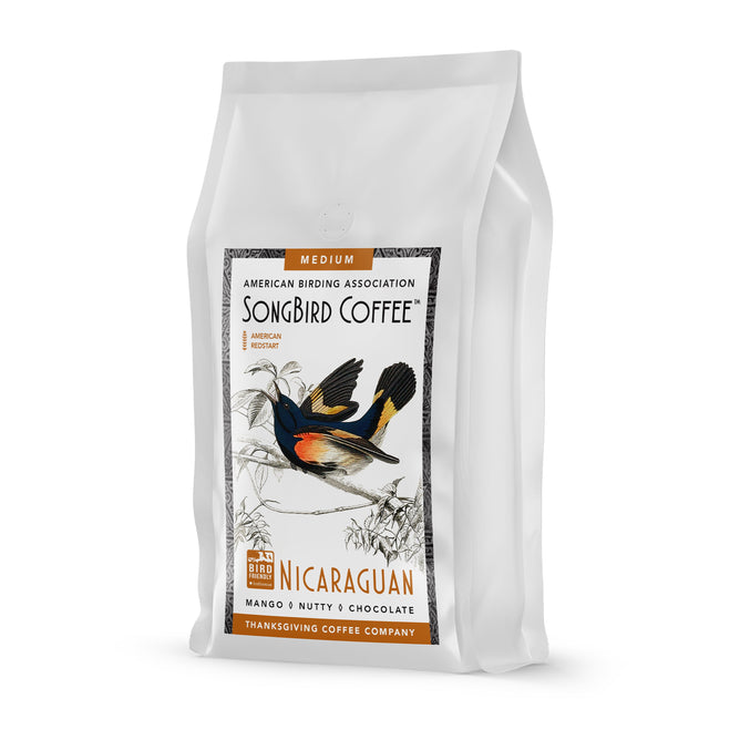 The Songbird Nicaraguan Medium Roast by Thanksgiving Coffee, sourced from Nicaraguas Miraflor Nature Reserve, features a colorful bird on the package. It reveals mango, nutty, and chocolate flavors and highlights its bird-friendly nature.