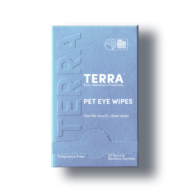 A blue box labeled Terra Pet Eye Wipes, Fragrance Free, gently removes tear stains, debris, and discharge. Features text: “Eco. Natural. Premium.” and “Gentle touch, clear eyes.” Contains 30 individually wrapped bamboo wipes. Plastic-free box.