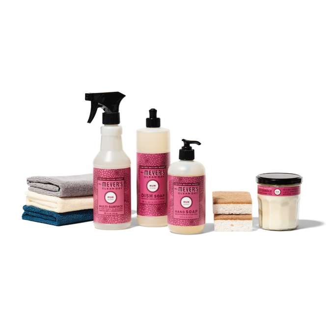 The Grove Collaborative autumn-abode-starter-set-mmcd includes a multi-surface cleaner, dish soap, hand soap, and a candle. These are displayed on a white background with folded towels and sponges, all featuring matching pink labels.