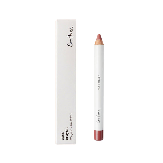 The Coco Crayon by Ere Perez features a minimalist design with a white base and red tip, standing upright next to its sleek white box with black text. Its hydrating creamy formula enhances this natural beauty crayon, all against a plain white background.