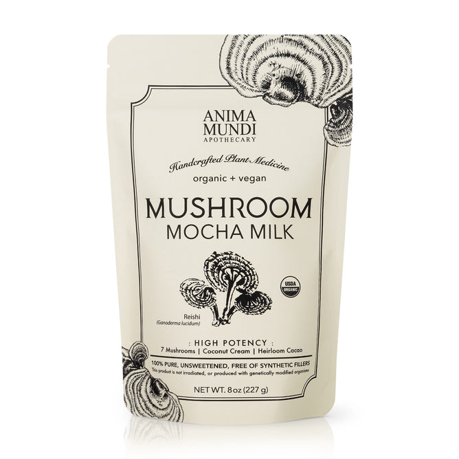 A beige upright pouch labeled MUSHROOM MOCHA MILK, Longevity Milk by Anima Mundi, displays black mushroom graphics and notes on heirloom cacao, 7 mushrooms, organic, vegan, unsweetened, and no synthetic fillers.