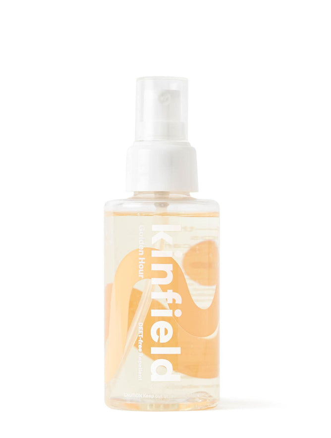 The Kinfield Golden Hour DEET-Free Mosquito Repellent features a clear spray bottle with a white cap and Kinfield in white text. It contains a translucent liquid and subtle orange graphics, infused with Indonesian citronella, ideal for outdoor adventures.