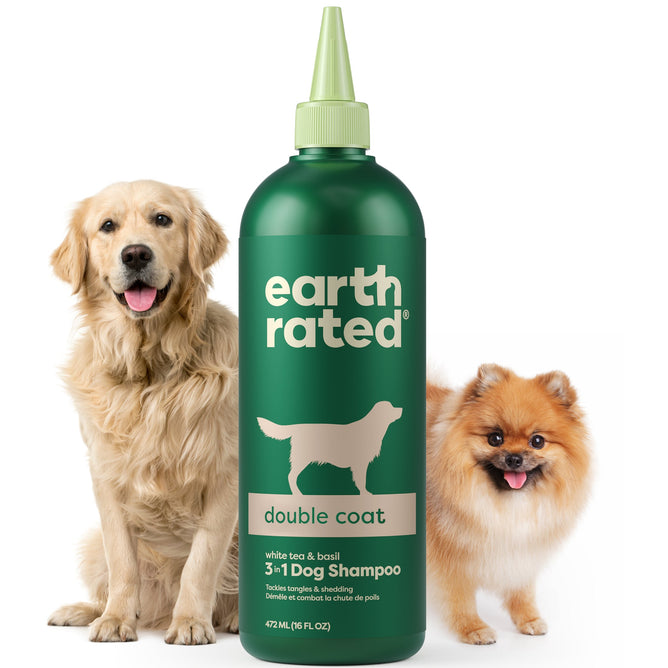 A large green bottle of Earth Rateds 3-in-1 Double Coat Dog Shampoo enriched with jojoba seed oil for shine stands in the center, flanked by a golden retriever and Pomeranian, showcasing its appeal for all dog breeds.