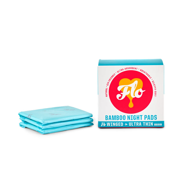 A package of FLO Bamboo Night Pads from Here We Flo is displayed, showcasing blue, ultra-thin pads with wings. The white box features red and yellow branding that highlights their ultra-absorbent protection and eco-friendly nature, made from organic bamboo.