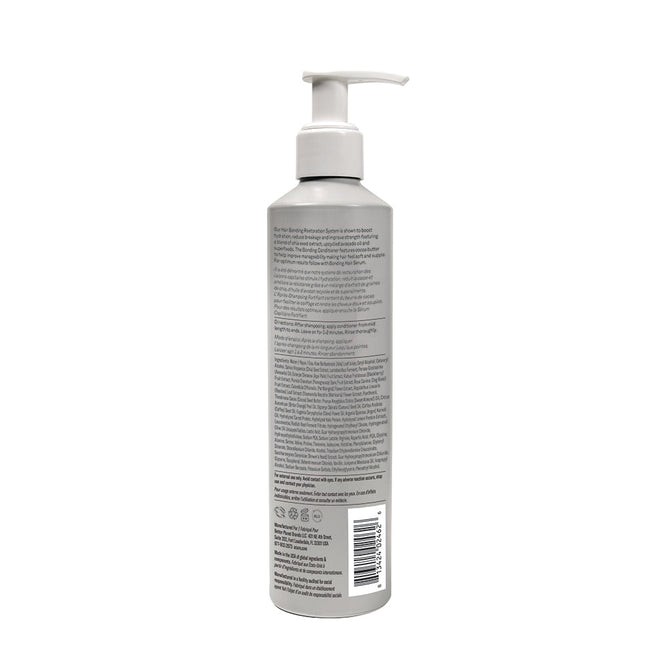 A tall, cylindrical gray bottle of Acure Bonding Conditioner with a white pump and detailed label stands upright against a plain white background. Infused with cocoa butter, it promises soft, supple hair.