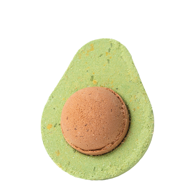 The Avocado Froth Bomb by Pacha Soap Co. is a bath fizz shaped like an avocado, with a green exterior and brown center resembling the pit. Against a white background, it features nourishing avocado oil for a luxurious soak.