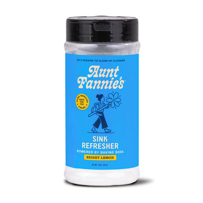 Aunt Fannies Sink Refresher in Bright Lemon scent has a blue label with white text and a cartoon person holding a flower. This 11.5 oz multipurpose scrub uses baking soda to neutralize odors on sink surfaces effectively.
