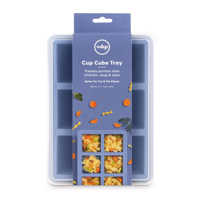 A blue silicone Cup Cubes Freezer Tray by W&P includes a packaging sleeve showing food cubes. The label states: ‘Freezes portion sizes of broth, soup & stew. Better For You & The Planet.’ It features six square compartments and a BPA-free white lid.