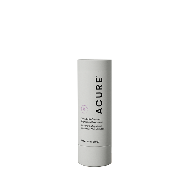 A cylindrical stick of Acure Coconut & Lavender Magnesium Deodorant with a white label stands upright. The minimalistic black text and small lavender icon are featured on the label. Net weight: 2.5 oz (70 g).