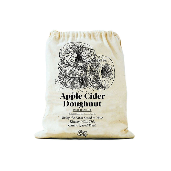 The cream-colored cloth bag from FarmSteady features a vintage-style illustration with the text Apple Cider Doughnut Baking Mix. Ideal for those who love homemade treats, these delicious doughnuts are dusted with cinnamon sugar.