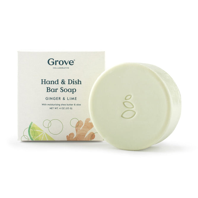 A round, light-colored soap bar with three embossed leaves sits before its package reading Grove Co. All-Purpose Hand & Dish Bar Soap. This high-sudsing, plastic-free soap offers a refreshing Ginger-Lime scent.