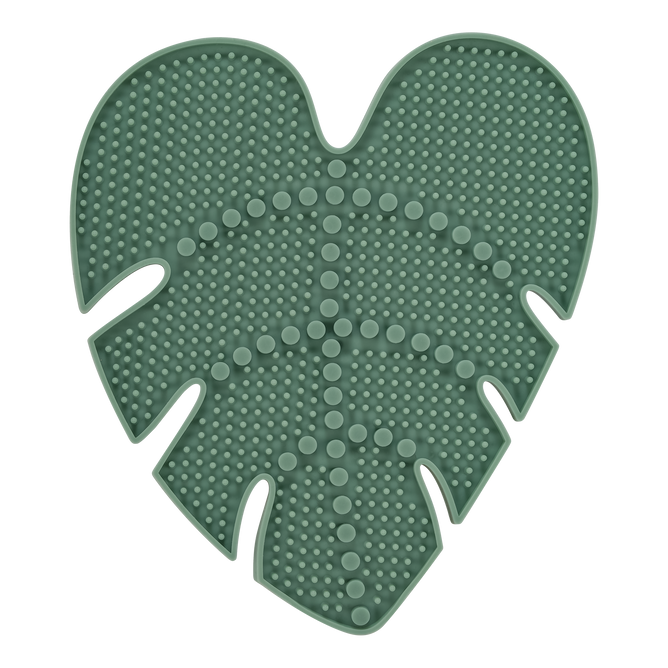 The EcoTools Eco Makeup Brush Cleansing Pad, crafted from cruelty-free, dark green silicone and shaped like a monstera leaf, features a textured surface with raised bumps and lines, perfect for efficiently cleaning makeup brushes while offering both functionality and style.