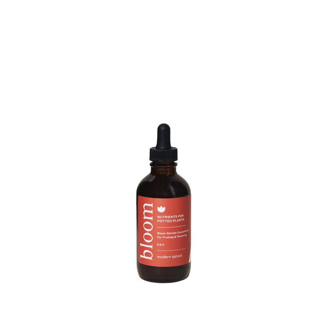 The Plant Nutrient - Bloom by Modern Sprout is in a brown glass bottle with a dropper cap, featuring a red label with white text. Its an organic-based nutrient for blooming houseplants, elegantly centered on a pristine white background.