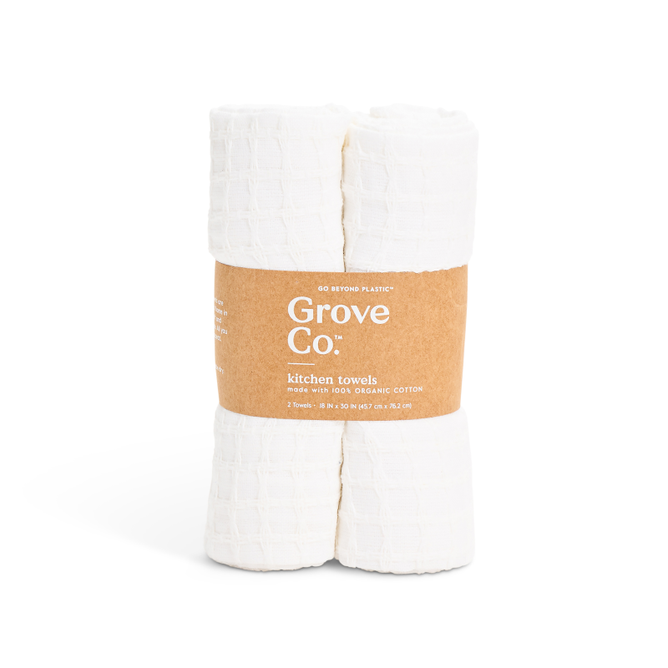 Two absorbent, quick-drying Grove Co. Organic Cotton Textured Kitchen Towels, featuring a waffle pattern for efficient drying, are rolled and secured with a brown paper band displaying product details.