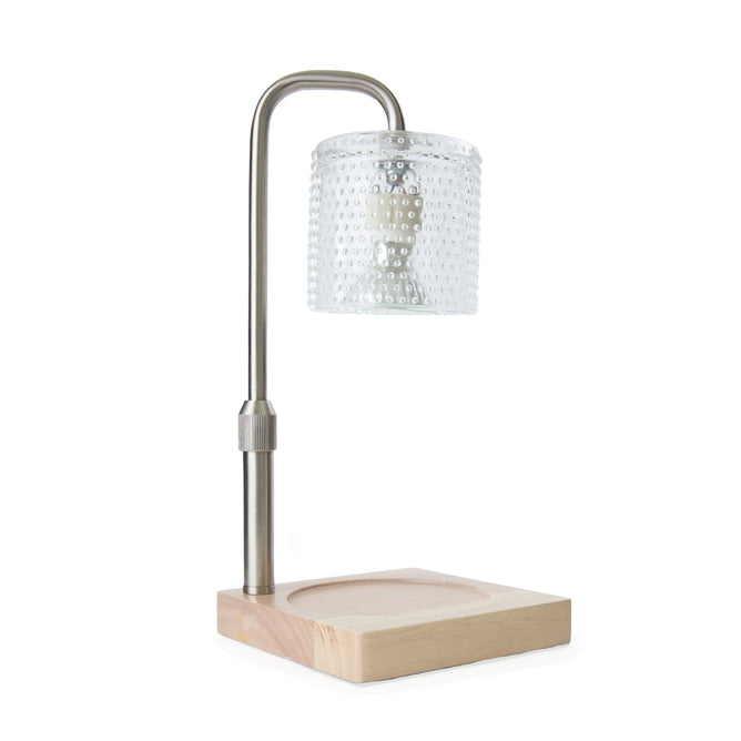 The Hobnail Candle Warmer Lamp by Candle Warmers Etc. boasts a modern design with an adjustable stem and a curved metal arm, complemented by a textured glass shade. Its light-colored wooden base with a circular groove adds to its minimalist and neutral aesthetic.