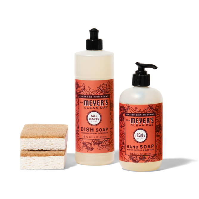 Grove Collaboratives crisp-clean-sinkside-set includes two Meyer’s Clean Day Fall Leaves Scent soaps—dish and hand—with orange floral labels. Two sponges sit to the left, one tan and one white-layered.