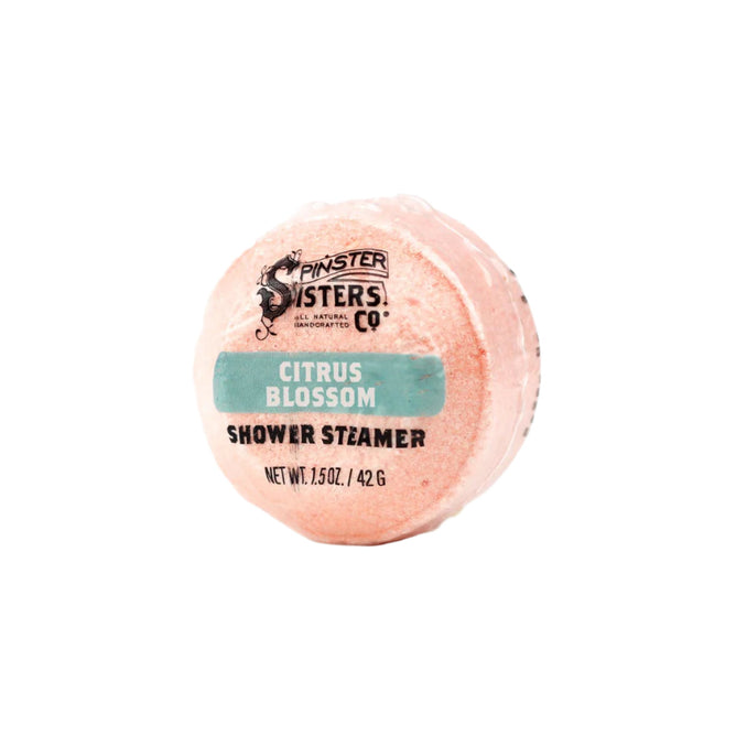 The Citrus Blossom Shower Steamer by Spinster Sisters Co. is a 1.5 oz/42 g pink shower steamer wrapped in plastic with a turquoise band. Infused with essential oils for aromatherapeutic effects, it promises to enhance your shower experience.