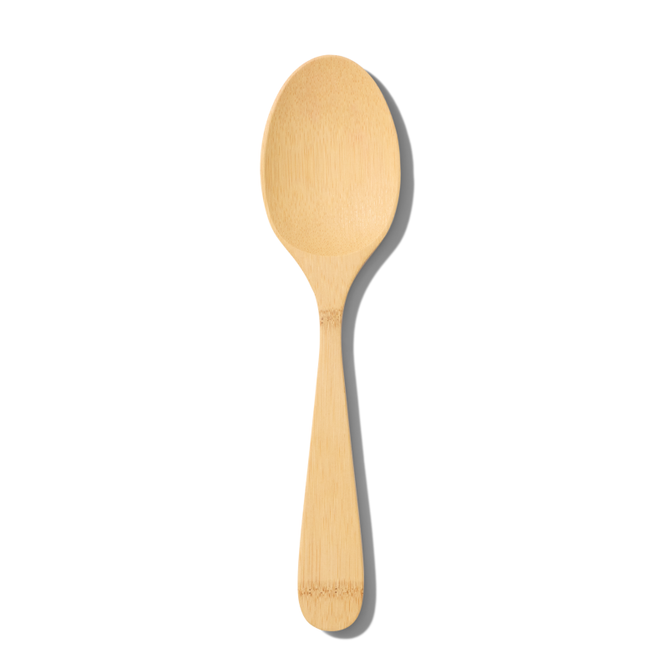 The Grove Co. Bamboo Serving Spoon, made from FSC-certified bamboo and boasting a smooth finish, is elegantly displayed against a white background with a soft shadow to its right, emphasizing its eco-friendly charm.