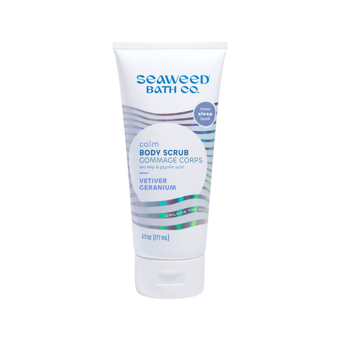 A 6 fl oz (177 mL) tube of The Seaweed Bath Co.s Calm Body Scrub featuring sea kelp, vetiver, and geranium scents in white packaging with blue and green accents. Includes bilingual text and uses AHA glycolic acid for gentle exfoliation to refresh skin.