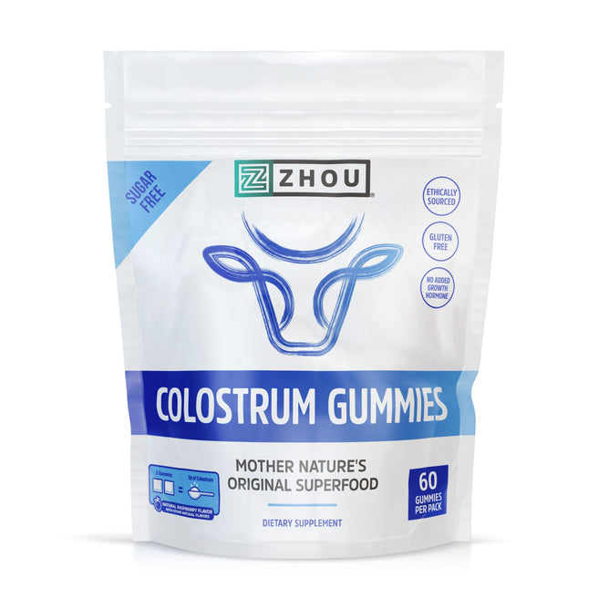 The Zhou Nutrition Colostrum Gummies Gummy package features a blue and white design with a cows head illustration and is labeled as Mother Natures Original Superfood. It includes 60 sugar-free, ethically sourced bovine colostrum gummies.
