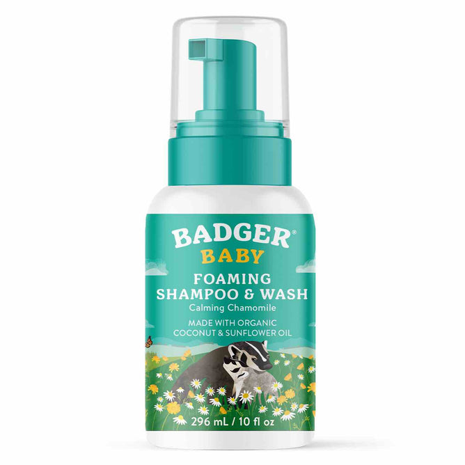 A 296 ml bottle of Badger Balm Baby Foaming Shampoo & Wash features a teal and green label with daisies and a badger illustration. This pediatrician-tested, gentle, organic formula contains calming chamomile, coconut oil, and sunflower oil.