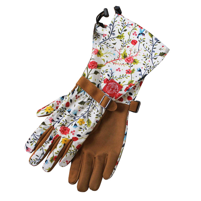 The Arm Saver Gloves by Womanswork showcase floral-patterned fabric with tan leather palms and fingertips, featuring a vibrant mix of red, yellow, and blue flowers intertwined with green vines. Buckled wrist straps highlight the quality craftsmanship of this woman-owned brand.