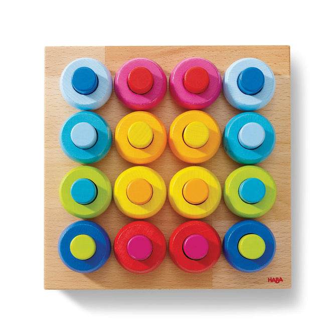 The HABA Rainbow Whirls Wooden Sorting and Stacking Game is a Montessori toy with a wooden board featuring four rows of colorful circular knobs with two rings each. With shades of blue, pink, orange, yellow, red, and green on white, its ideal for fine motor skill development.