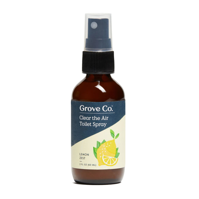 A 2 fl oz bottle of Grove Co. Clear the Air Toilet Spray (VIP), a natural lemon zest fragrance air freshener, comes in an amber bottle with a blue label featuring a lemon illustration and is topped with a black spray nozzle.