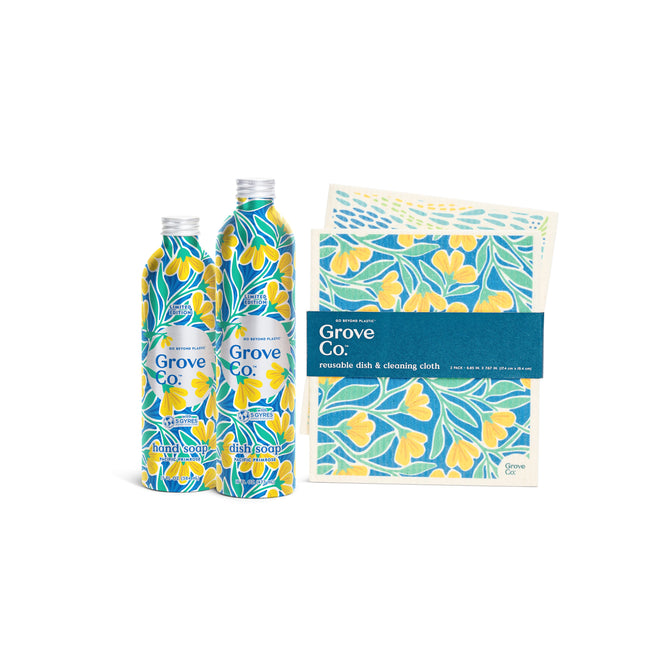 Two bottles of Grove Collaboratives Scented Trio - Spring Collection dish soap with a limited edition yellow floral pattern sit next to reusable dish and cleaning cloths in the matching Pacific Primrose design.
