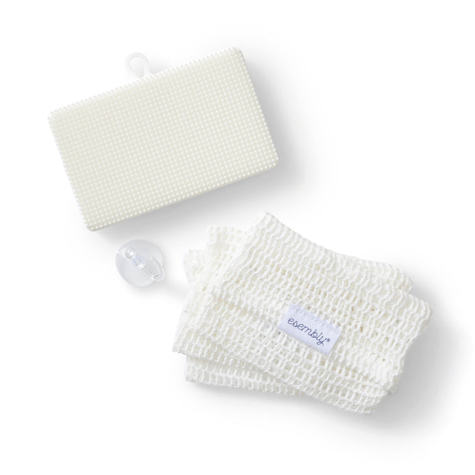 A neatly arranged set of bath items on a white background, featuring a textured rectangular sponge, mesh washcloth with an esembljr tag, and a suction cup hook—all part of the GoTwo™ Kitchen Sponge Set by Esembly Baby.