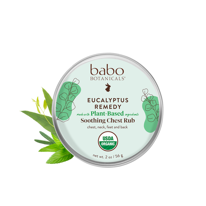 A round tin labeled Eucalyptus Remedy Organic Soothing Chest Rub by Babo Botanicals features plant illustrations. Its ideal for use on the chest, neck, feet, and back as a baby chest rub. Made with Plant-Based Ingredients and USDA Organic, it has a net weight of 2 oz/56 g.