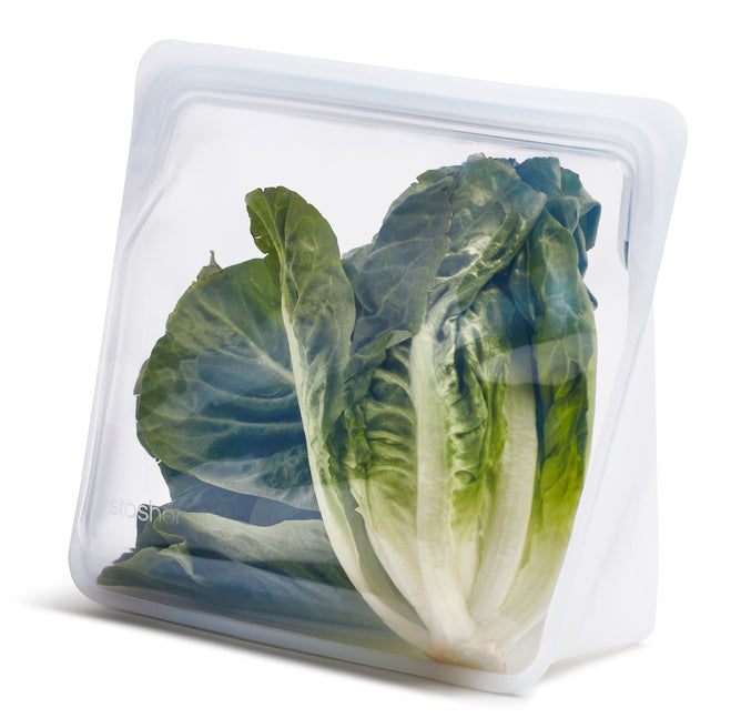 A head of lettuce stands upright in a Stasher Reusable Stand-Up Mega Bag (VIP Discount) on a white background, highlighting an eco-friendly solution for keeping produce fresh.