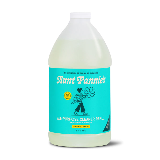 A gallon-sized bottle of Aunt Fannies All-Purpose Cleaner Refill with a turquoise label depicting a person holding a flower. Features Bright Lemon, Powered by Vinegar, and plant-based surfactants for an eco-friendly clean.