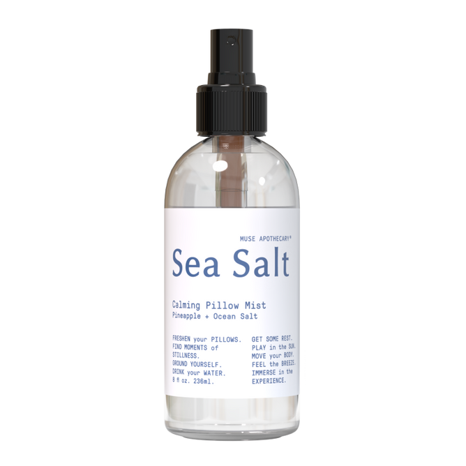 The clear Calming Pillow Mist by Muse Apothecary features a refreshing pineapple and ocean salt scent enriched with natural essential oils. Its 8 fl oz (236 ml) bottle has a black spray nozzle and highlights freshness, rest, and experience.