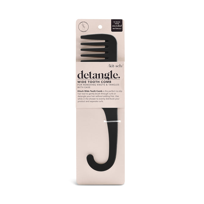A black Kitsch Consciously Created Wide Tooth Comb with a hook handle rests in beige packaging. Labeled detangle, its perfect for removing knots effortlessly, and its no-slip texture ensures easy handling.